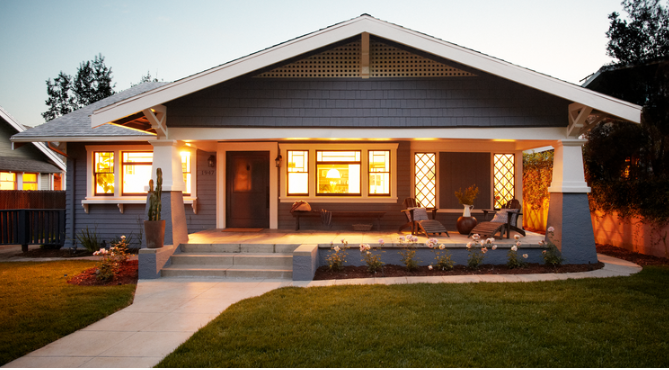 front of a craftsman style home with green lawn and clear evening sky